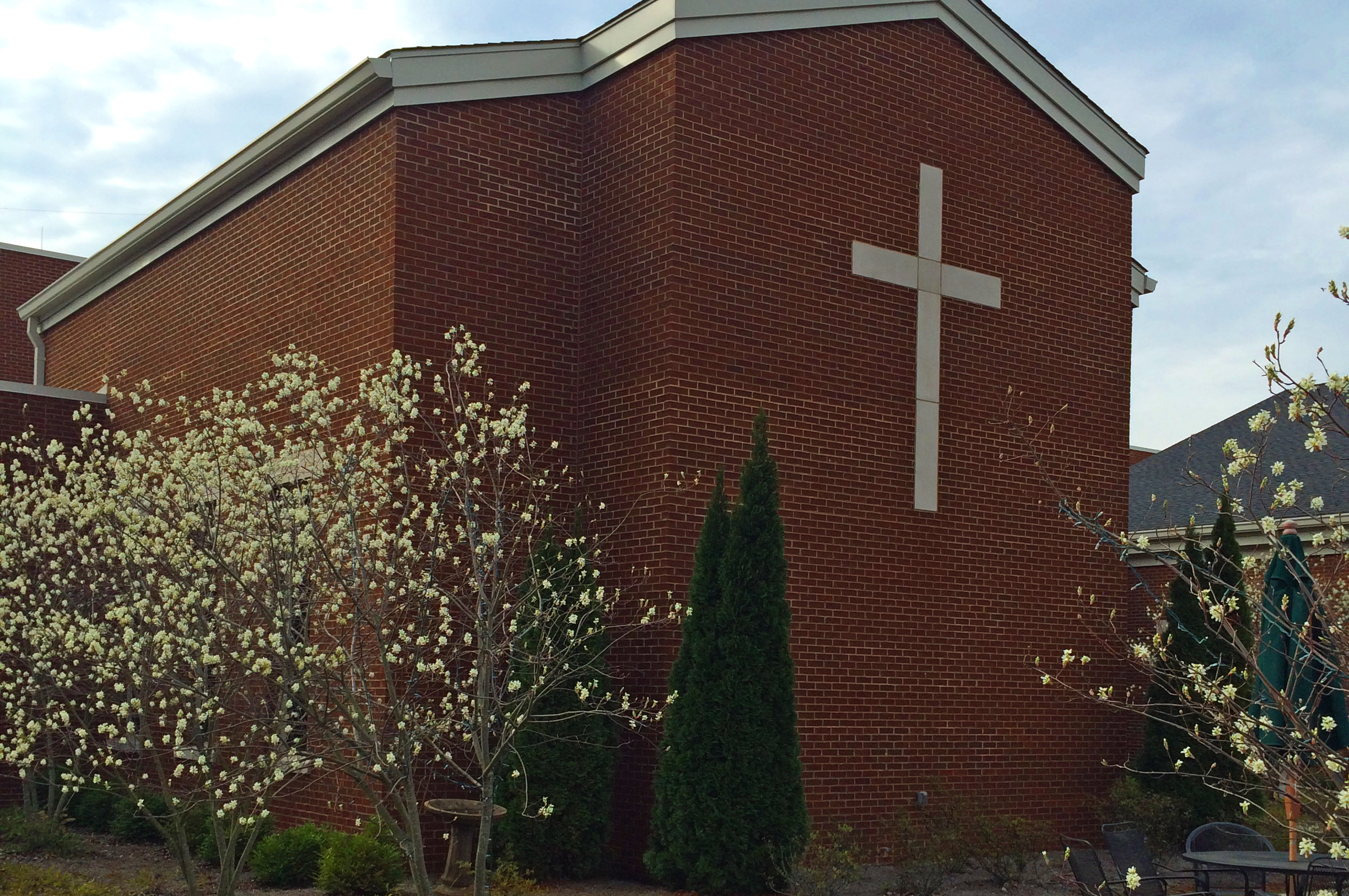 flowering trees outside Pope John Paul II Catholic High School white cross on the outside of the building